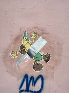 Street art showing partially ripe banana taped to the wall